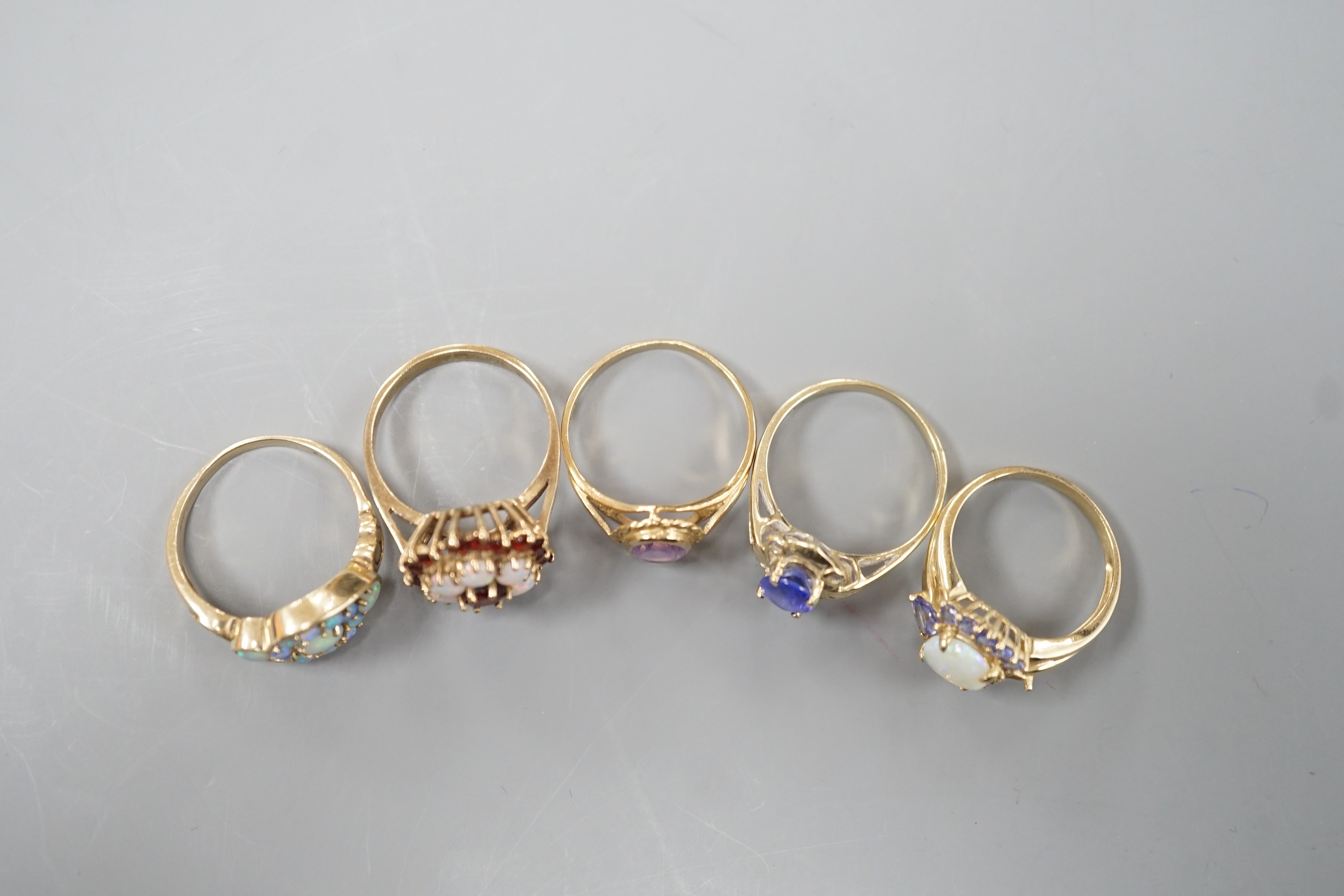 Five assorted modern 9ct gold and gem set dress rings, including, white opal cluster, garnet and white opal cluster and amethyst